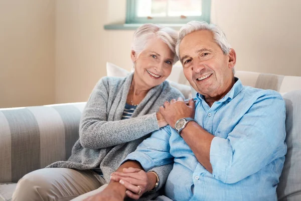 A vida gira em torno das pessoas que importam para você. Tiro de um casal de idosos relaxando juntos no sofá em casa. — Fotografia de Stock