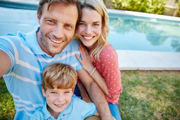 Capturar o momento para que dure para sempre. Retrato de uma família feliz fazendo um auto-retrato juntos fora. — Fotografia de Stock