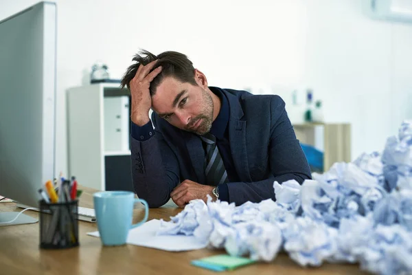 O trabalho continua a acumular-se. Tiro de um empresário estressado sentado em sua mesa sobrecarregado com papelada. — Fotografia de Stock
