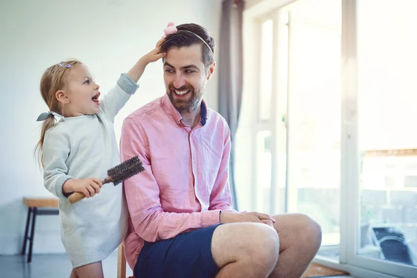 Futur coiffeur en devenir. Tourné d'une adorable petite fille brossant les cheveux de son père à la maison. — Photo