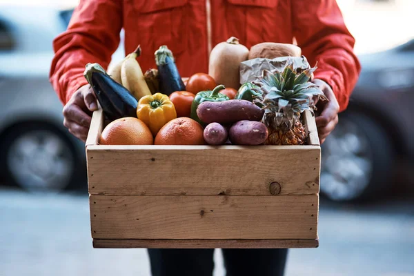 문으로 신선 한 권리를 전달했습니다. 과일 과 야채가 가득 들어 있는 상자를 운반하는 사람이 걸려 있는 총성이 들렸다. — 스톡 사진