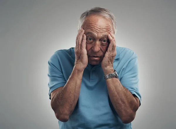 De stress kan me doden. Schot van een oudere man die zijn handen in zijn gezicht klemt in een studio tegen een grijze achtergrond. — Stockfoto