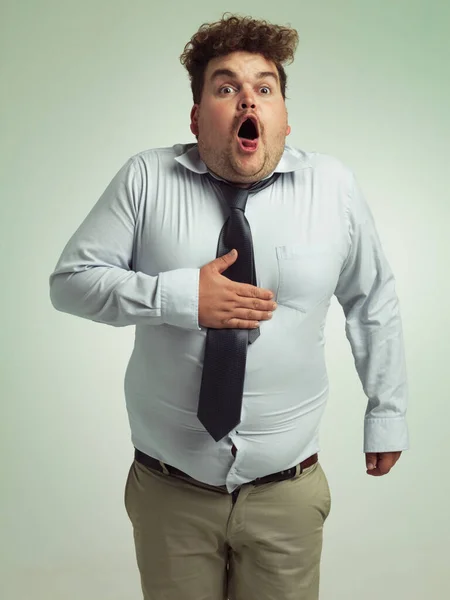 Just a bit of gas. Shot of an overweight man holding his chest. — Stock Photo, Image