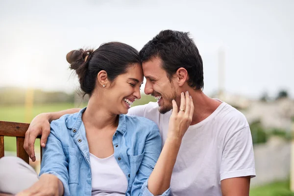 Det finns ingen bättre känsla av kärlek. Beskuren bild av ett kärleksfullt ungt par som sitter på en bänk utomhus. — Stockfoto