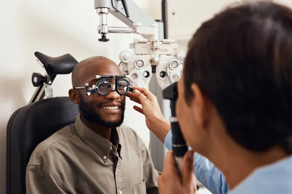 İlk görüşte berraktı. Bir optometristin yeni gözlük taktığı genç bir adamın fotoğrafı.. — Stok fotoğraf