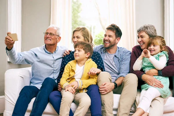 Tohle je naše velká a krásná rodina. Snímek multigenerační rodiny sedící doma na gauči. — Stock fotografie