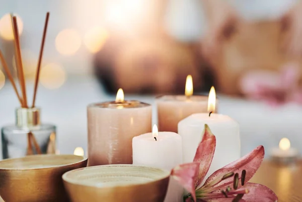 Candles to set some ambiance. Shot of a relaxed an cheerful young woman getting a massage indoors at a spa. — Stock Photo, Image