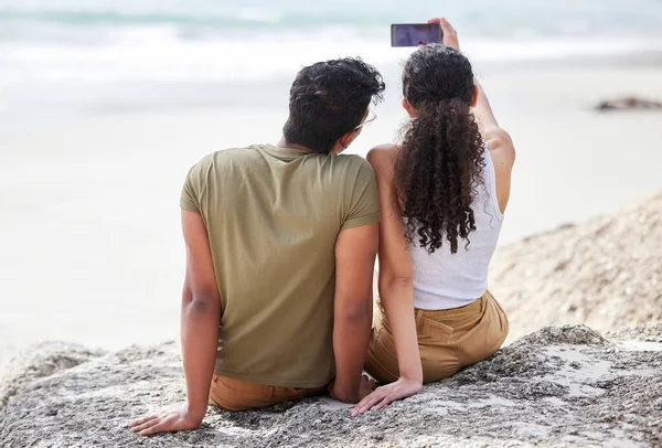 Les selfies d'été sont nos préférés. Tourné d'un jeune couple prenant un selfie à la plage. — Photo