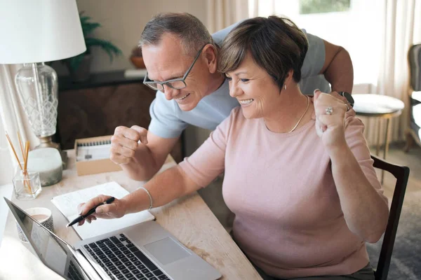 Creo que acabamos de recibir buenas noticias. Shot de un marido maduro y la esposa usando un ordenador portátil juntos. — Foto de Stock