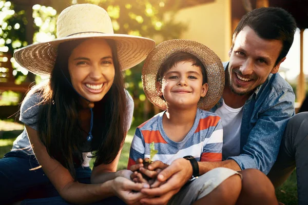 Abbiamo tutti le dita verdi. Ritratto di una famiglia felice che fa giardinaggio insieme nel loro cortile. — Foto Stock