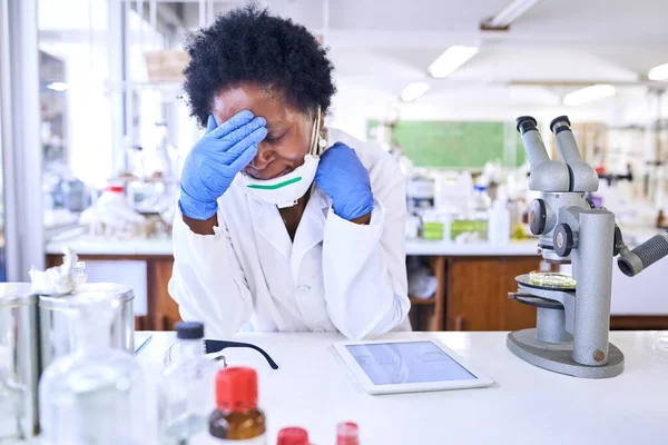 Empieza a sentir la tensión. Fotografía de una científica que parece estresada mientras trabaja en un laboratorio. — Foto de Stock