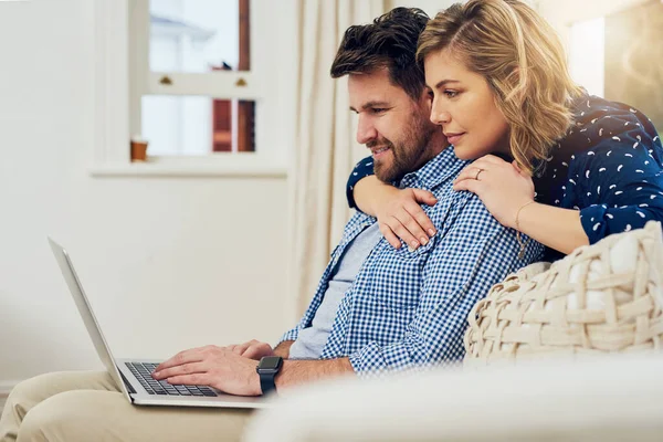 Navegando na internet juntos. Tiro de um casal atraente usando um laptop juntos em casa. — Fotografia de Stock