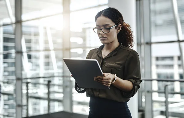Hou je ogen gericht op je connecties. Gesneden foto van een aantrekkelijke jonge zakenvrouw met behulp van een digitale tablet in een modern kantoor. — Stockfoto