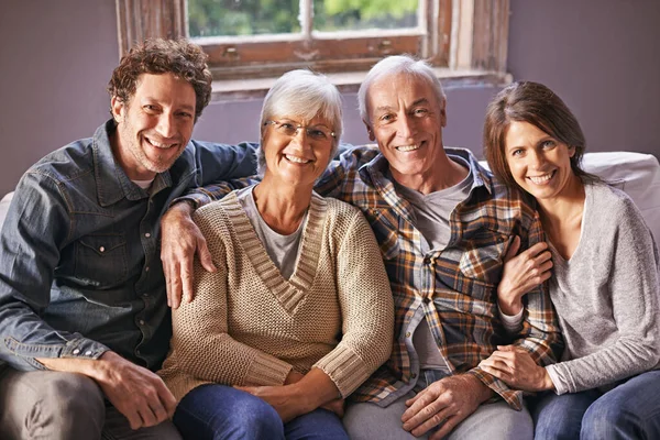 U příbuzných. Portrét šťastných dospělých rodičů sedících se svými dospělými dětmi doma. — Stock fotografie