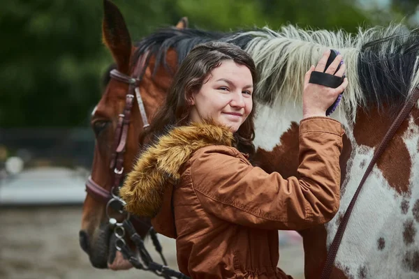 Celui qui a dit que tu ne pouvais pas acheter le bonheur n'a jamais eu de poney. Prise de vue d'une adolescente brossant les cheveux de ses poneys sur une ferme. — Photo