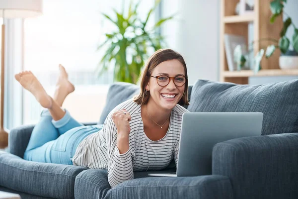 Evet, bir milyon takipçiye ulaştım. Mutlu bir genç kadının evdeki kanepede dizüstü bilgisayarını kullanırken tam boy fotoğrafı.. — Stok fotoğraf