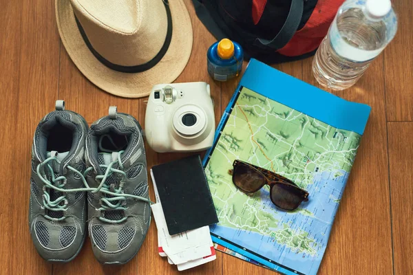 Há tanto para explorar. Tiro de ângulo alto de itens essenciais de viagem em uma mesa. — Fotografia de Stock