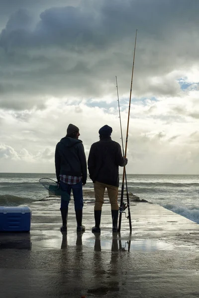 それは素晴らしい一日でした...早朝に海で釣りをする2人の若い男性の完全な長さのショット. — ストック写真