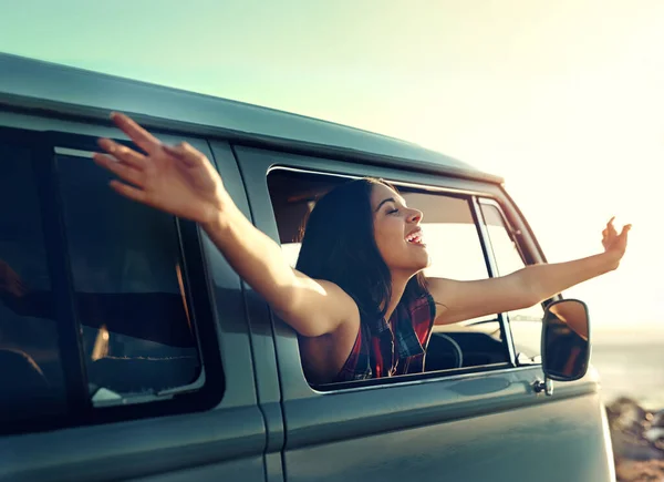 La vie est la plus grande route à parcourir. Prise de vue d'une jeune femme penchée par la fenêtre de sa camionnette les bras tendus. — Photo