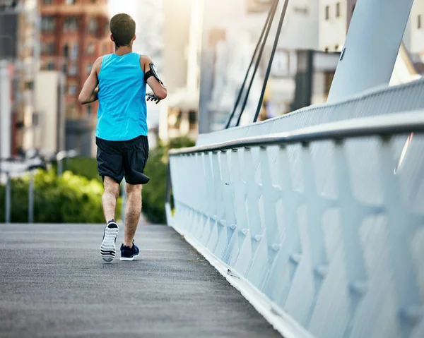 Fitness is een reis. Achteraanzicht van een knappe jongeman aan het trainen in de stad. — Stockfoto