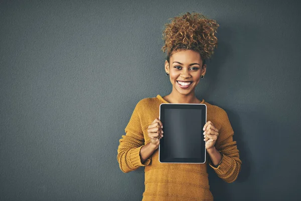 Eu recomendo que você dê uma olhada em algum momento. Retrato de estúdio de uma jovem segurando um tablet digital com uma tela em branco contra um fundo cinza. — Fotografia de Stock