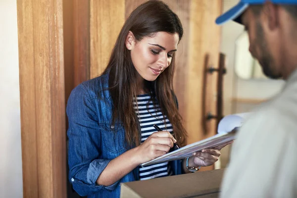 Sólo necesito su firma, por favor. Foto recortada de un mensajero haciendo una entrega a un cliente en su casa. —  Fotos de Stock