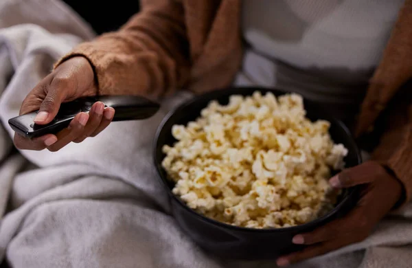 Time to binge watch your favourite show. High angle shot of an unrecognizable woman eating popcorn while watching tv at home. — Stock Photo, Image