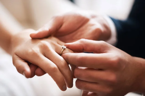 Geen diamant kan zich meten met deze kostbare liefde. Gesneden foto van een onherkenbare bruidegom die een diamanten ring om zijn vrouw 's vinger doet tijdens hun bruiloft.. — Stockfoto