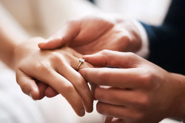 No diamond can compare to this precious love. Cropped shot of an unrecognizable groom putting a diamond ring on his wifes finger during their wedding. — Stock Photo, Image