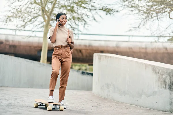 Es gibt keine Abkürzungen zu irgendeinem Ort, den es sich zu besuchen lohnt. Aufnahme einer attraktiven jungen Studentin mit ihrem Handy beim Skateboarden auf dem Campus. — Stockfoto