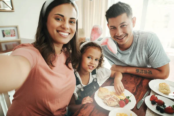 Diese Frühstückstage der Familie einfangen. Aufnahme eines jungen Paares, das ein Selfie macht, während es mit seiner Tochter zu Hause frühstückt. — Stockfoto