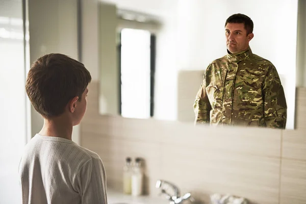 Eines Tages, wenn ich erwachsen werde. Rückansicht eines kleinen Jungen, der einen Soldaten sieht, der sich im Spiegel spiegelt. — Stockfoto
