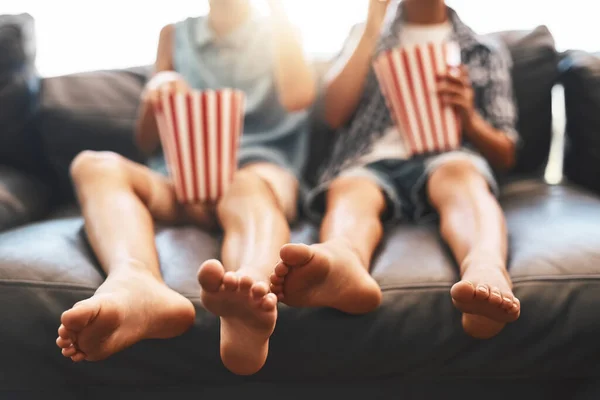 Es hora de la película. Recorte de un hermano y una hermana comiendo palomitas de maíz y viendo películas en el sofá en casa. —  Fotos de Stock