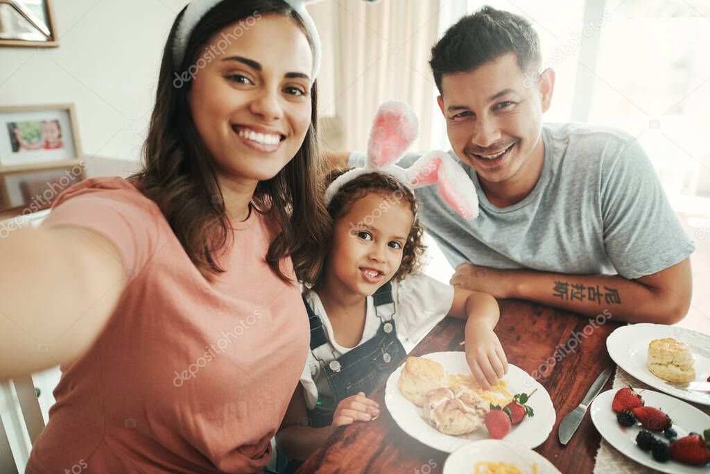 Capturing those family breakfast days. Shot of a young couple taking a selfie while having breakfast with their daughter at home.