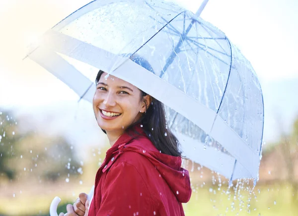 My umbrellas got me covered. Shot of a young woman holding an umbrella in the rain outside. — Stock Photo, Image