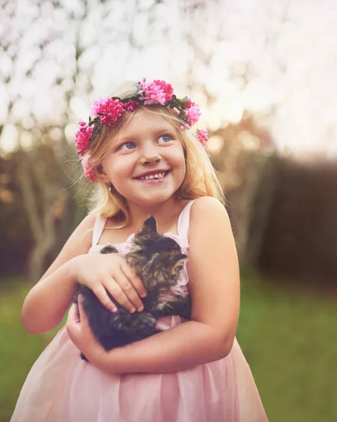 Chce jít s námi domů. Postřelen šťastný holčička drží kotě a dívá se do dálky, zatímco stojí venku v přírodě. — Stock fotografie