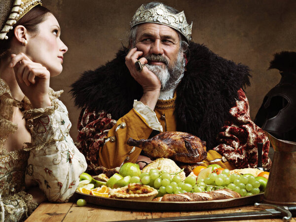 Royal life can be tedious.... A bored queen sitting alongside her husband at a banquet.