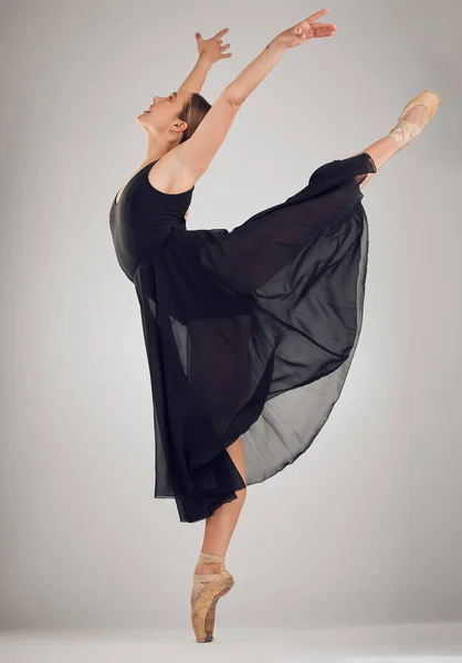 ダンスは一人でできる技術です。フル長さショットの魅力的な若い女性バレエダンサーでスタジオでグレーの背景. — ストック写真