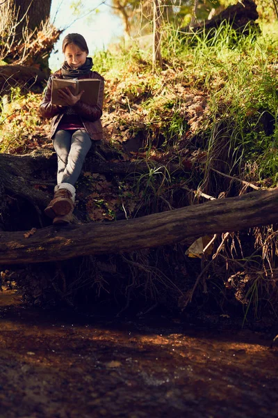 Es ist ihr Lieblingsplatz zum Lesen. Aufnahme eines jungen Mädchens beim Lesen eines Buches im Freien. — Stockfoto