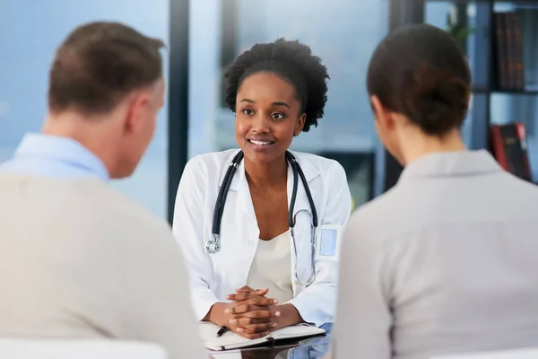 Cuidaré bien de ti. Recorte de una doctora hablando con una pareja casada en su consultorio. — Foto de Stock