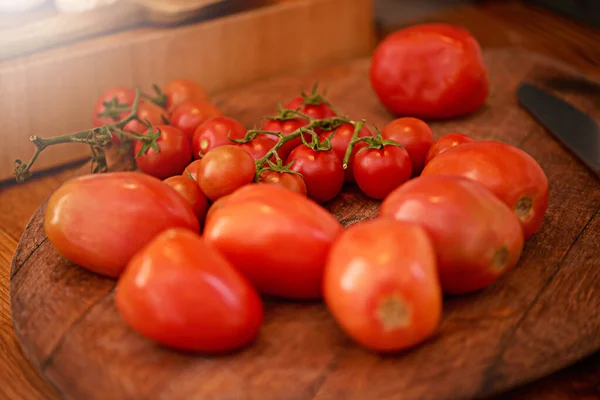Dokonale baculatá rajčata. Snímek švestky a cherry rajčat na stole v kuchyni. — Stock fotografie