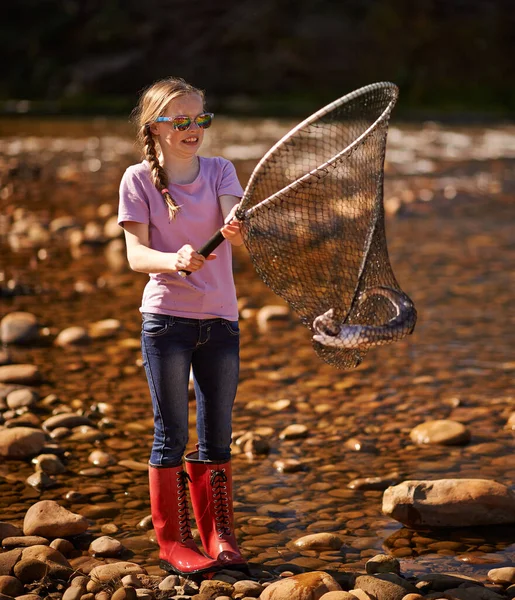 Ne ho una. Girato di una giovane ragazza che tiene una rete da pesca con un pesce dentro. — Foto Stock