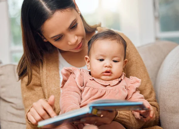 Le encanta un buen libro de fotos. Fotografía de una mujer leyendo a su bebé. — Foto de Stock