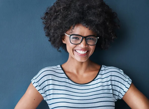Ik kies geluk boven alles. Studio portret van een aantrekkelijke en zelfverzekerde jonge vrouw met een bril tegen een blauwe achtergrond. — Stockfoto