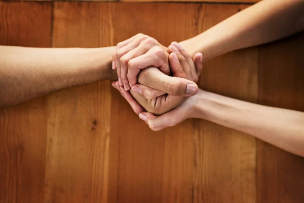 Sono con te in ogni momento. Colpo ritagliato di due persone irriconoscibili che si tengono per mano mentre siedono a un tavolo all'interno durante il giorno. — Foto Stock