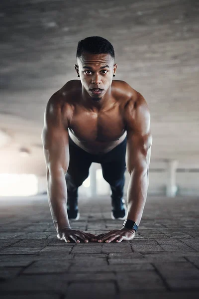 So sieht Macht aus. Ganztägiges Porträt eines hübschen jungen Mannes, der Liegestütze macht, während er draußen trainiert. — Stockfoto