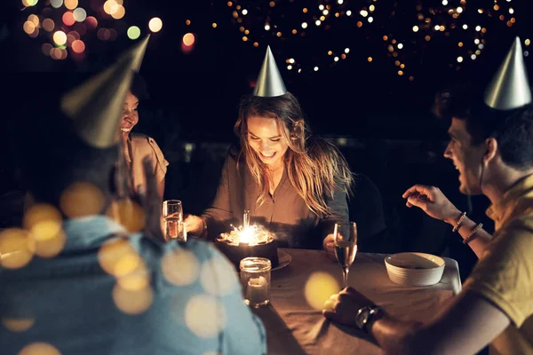 Elle fête son anniversaire avec tous ses amis proches. Tournage d'un groupe d'amis célébrant un anniversaire ensemble autour d'une table lors d'un rassemblement en plein air le soir. — Photo