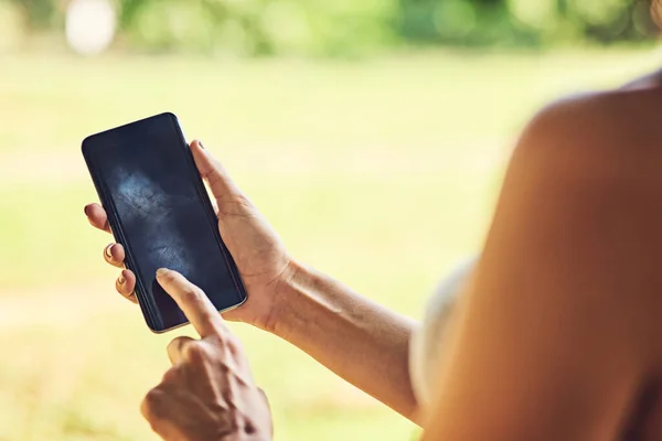 Tienes tu dispositivo actualizado con las últimas aplicaciones. Primer plano de una mujer irreconocible usando un teléfono celular al aire libre. — Foto de Stock