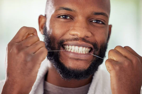 Faz do fio dental uma parte da tua rotina. Tiro de um jovem que usa fio dental em casa. — Fotografia de Stock