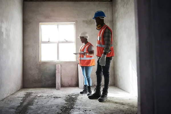 Minden szoba megkapja az öt csillagos kezelést. Egy fiatal férfi és nő digitális táblagépet használ, miközben egy építkezésen dolgozik.. — Stock Fotó